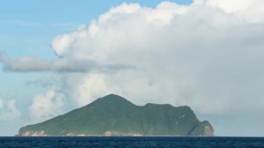Guishan Adası 'nın dramatik bulutlu görkemli manzarası. Bereketli yeşil ada mavi okyanusa ve gökyüzüne karşı çok güzel tezat oluşturuyor. Toucheng, Yilan, Tayvan.