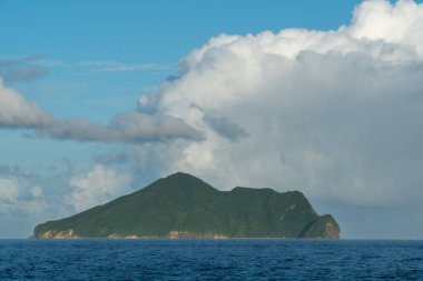 Guishan Adası 'nın dramatik bulutlu görkemli manzarası. Bereketli yeşil ada mavi okyanusa ve gökyüzüne karşı çok güzel tezat oluşturuyor. Toucheng, Yilan, Tayvan.