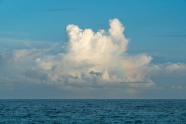 Güneşli bir öğleden sonra, kümülüs bulutları Pasifik Okyanusu boyunca devasa gölgeler bıraktı. Bulutların tabanı ufuk çizgisine kayar, ölçek ve merak duygusu yaratır. Yilan County, Tayvan.