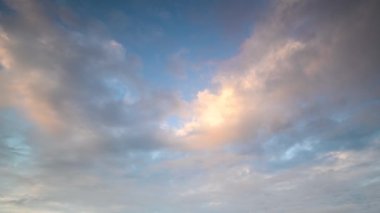 Gün batımında. Yumuşak dalgalar, sakin bir koyda yuvarlak kayalara çarpar. Gökyüzü durgun suyu yansıtan pembe ve mor yumuşak renklerle boyanmıştır. Suao, Yilan, Tayvan.