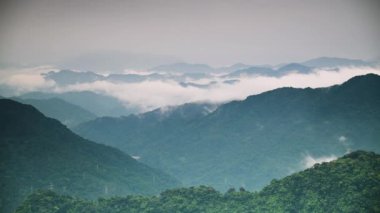 Huzurlu bir dağ silsilesi bir sis örtüsüyle örtülmüş, rüya gibi ve ruhani bir atmosfer yaratıyor. Tepelerin ve vadilerin katmanları mesafeye kadar uzanıyor. Shizitou Dağı, Tayvan.