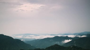 Huzurlu bir dağ silsilesi bir sis örtüsüyle örtülmüş, rüya gibi ve ruhani bir atmosfer yaratıyor. Tepelerin ve vadilerin katmanları mesafeye kadar uzanıyor. Shizitou Dağı, Tayvan.