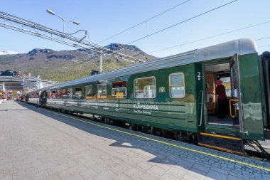 Flam, Norveç - 2 Mayıs 2024: Flam Demiryolu sersemletici Norveç dağları boyunca esiyor, yolculara fiyortların ve şelalelerin nefes kesici manzarasını sunuyor.