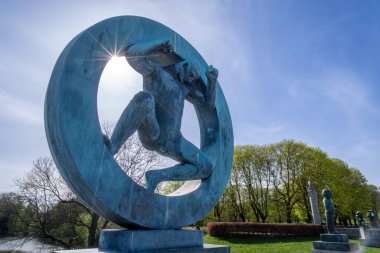 Oslo, Norveç - 3 Mayıs 2024 Vigeland Heykel Parkı 'nın manzarasına hükmeden dairesel bir biçimden kurtulan bir adamın çarpıcı bronz heykeli.