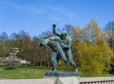 Oslo, Norveç - 3 Mayıs 2024: Vigeland Heykel Parkı 'nda heybetli bir bronz heykel, kadın tutan bir adamı resmediyor. İnsani bağların ve duyguların dışa vurumsal bir tasviri..