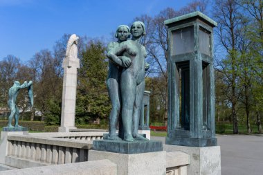 Oslo, Norveç - 3 Mayıs 2024: Vigeland Heykel Parkı 'nda kucaklaşan bir çiftin bronz heykeli huzur içinde duruyor. Bu ikonik çalışma aşkı, birliği ve insan ilişkilerinin güzelliğini sembolize eder..