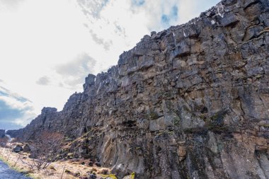 Kuzey Amerika ve Avrasya tektonik plakaları arasındaki ikonik yarık vadisiyle birlikte İzlanda 'daki Thingvellir Ulusal Parkı' nda bir yürüyüşçü yol boyunca yürür..
