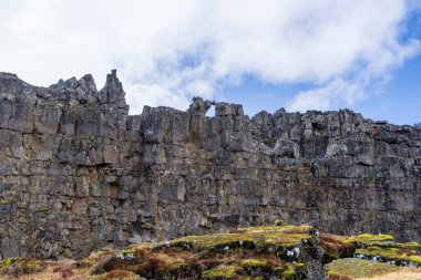 Kuzey Amerika ve Avrasya tektonik plakaları arasındaki ikonik yarık vadisiyle birlikte İzlanda 'daki Thingvellir Ulusal Parkı' nda bir yürüyüşçü yol boyunca yürür..