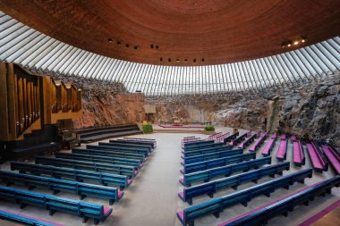 Helsinki, Finlandiya - 7 Mayıs 2024: Temppeliaukio Kilisesi eşsiz kaya tavanı ve doğal ışıklandırması ile göz kamaştırıcı bir iç mekan. Tahta banklar ve boru orgu sıcak ve davetkar bir atmosfer yaratır..