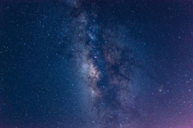 Sakin bir denizin üzerinde gece gökyüzüne uzanan Samanyolu 'nun nefes kesici bir görüntüsü. Galaksimizin yıldızlı kuşağı tüm ihtişamıyla görülebilir. Suao, Yilan County, Tayvan.