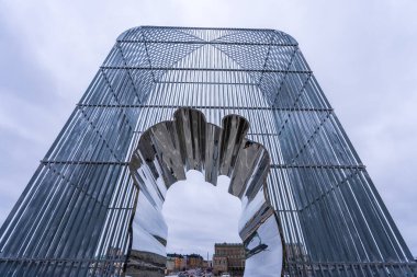 Stockholm, Sweden - May 9, 2024: Ai Weiwei's striking cage installation stands in front of the National Museum, its rigid structure contrasting with the delicate paper-cut figures inside. clipart