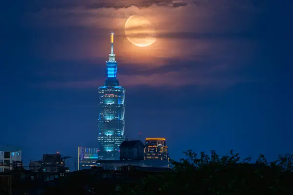 Gece Taipei 'nin çarpıcı manzarası. Hilal ay, ikonik Taipei' nin üzerinde zarafetle kıvrılıyor. Dajianshan, Tayvan, bu resim şehir ve gökyüzü güzelliğinin çarpıcı bir karışımı..