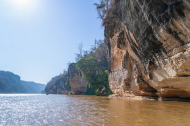 Eşsiz erozyon kalıpları ve yemyeşil bitki örtüsü olan kireçtaşı kayalıkları. Sarı nehir suyu boyunca kano gezisi. Manambolo Nehri, Madagaskar.