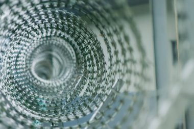 Dikenli tel bobinin yakın çekimi soyut bir geometrik desen yaratıyor. Keskin bıçakların karmaşık tasarımı arka plan olarak kullanmak için mükemmel, görsel olarak çarpıcı bir görüntü oluşturur. Tayvan.