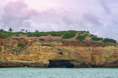 Karmaşık deniz mağaraları olan muhteşem sahil kayalıkları, altın ve kırmızımsı kaya oluşumlarının sergilendiği katmanlar. Turkuaz sular nefes kesici manzaraya ekleniyor. Algarve, Portekiz.