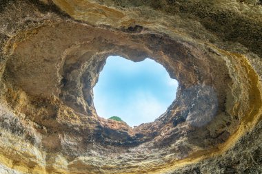 Kalp şeklinde bir tavan penceresi dünyanın en çarpıcı deniz mağaralarından biri olan Benagil Mağarası 'nın içini aydınlatır. Algarve, Portekiz.