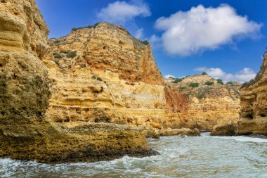 Altın uçurumlar ve dramatik deniz mağaralarının yer aldığı Algarve sahili nefes kesici bir manzara. Turkuaz sular engebeli kıyı şeridine çarpar ve çarpıcı bir doğal manzara yaratır. Portekiz.