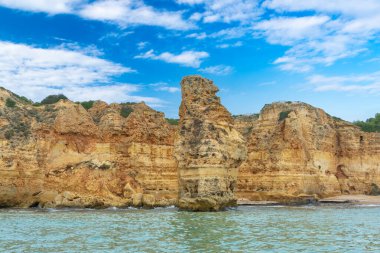 Alacakaranlıkta, zümrüt sularının üzerinde karmaşık deniz mağaralarıyla birlikte Altın Kıyı uçurumları yükseliyor. Dalgalar, Algarve ve Portekiz tarafından şekillendirilen şaşırtıcı kaya oluşumları.