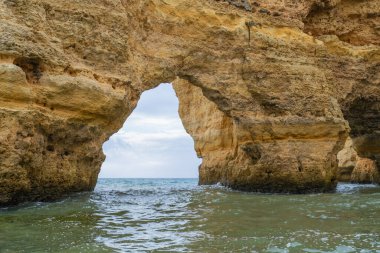 Karmaşık deniz mağaraları olan muhteşem sahil kayalıkları, altın ve kırmızımsı kaya oluşumlarının sergilendiği katmanlar. Turkuaz sular nefes kesici manzaraya ekleniyor. Algarve, Portekiz.