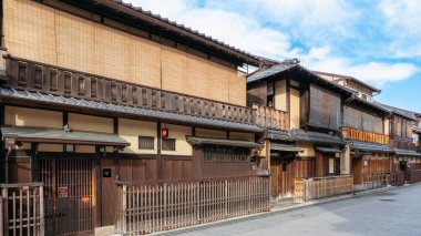 Kyoto, Japan - December 18, 2024: Traditional wooden houses with sliding paper doors and wooden latticework line the historic Hanami-koji Street in Kyoto, Japan. clipart