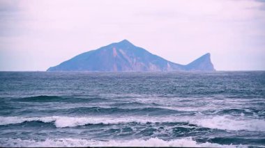 Tayvan, Yilan 'da sakin bir bahar sabahı, Kaplumbağa Adası' nın uzak siluetine giden dalgaların ritmik katmanlarını yakalar..
