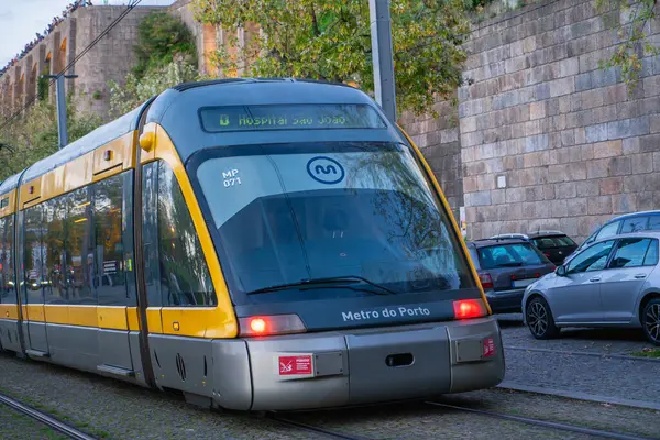 Porto, Portekiz - 10 Kasım 2024: Sarı ve gümüş renkli Porto metro Sao Bento İstasyonu 'nda durur. Tren, tarihi bir zemin karşısında modern şehir ulaşımını ön plana çıkarıyor..