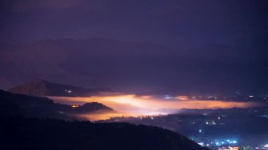 Yuchi 'nin dağ ormanlarında, bahar gecesi parlayan ışıkların ve sürüklenen sislerin mistik bir karışımını ortaya çıkarır, gerçeküstü bir ahenk yaratır..