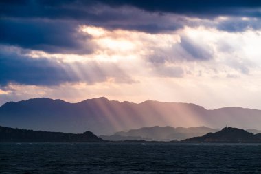 Tayvan Jinshan Bölgesi 'nde büyüleyici bir bahar gündoğumuna tanık olun. Bulutlar ve güneş ışığı çarpıcı deniz manzarası üzerinde şiirsel bir gölge ve ışık etkileşimi yaratır..