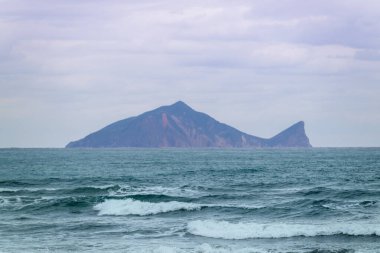 Tayvan, Yilan 'da sakin bir bahar sabahı, Kaplumbağa Adası' nın uzak siluetine giden dalgaların ritmik katmanlarını yakalar..