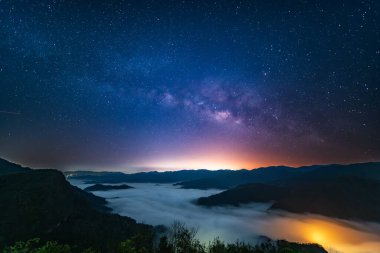 Samanyolu 'nun muhteşem manzarası yıldızlı gökyüzü ve dağlar üzerindeki bulutlar Xindian Bölgesi, New Taipei Şehri, Tayvan.