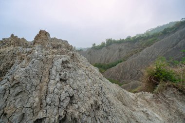 Tainan, Tayvan 'daki Caoshan Ay Dünyası' nın aşınmış beyaz çamur taşlı çorak topraklarına geniş bir bakış açısı. Kıraç, çorak arazide keskin tepeler ve seyrek bitki örtüsü ile derin dereler bulunur..