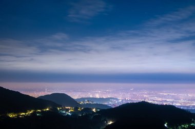 Datun Dağı 'ndan ele geçirilen Taipei şehrinin çarpıcı bir gece görüntüsü. Şehir ışıkları ufku aydınlatıyor, önplandaki karanlık dağ siluetleriyle güzel bir tezat oluşturuyor..