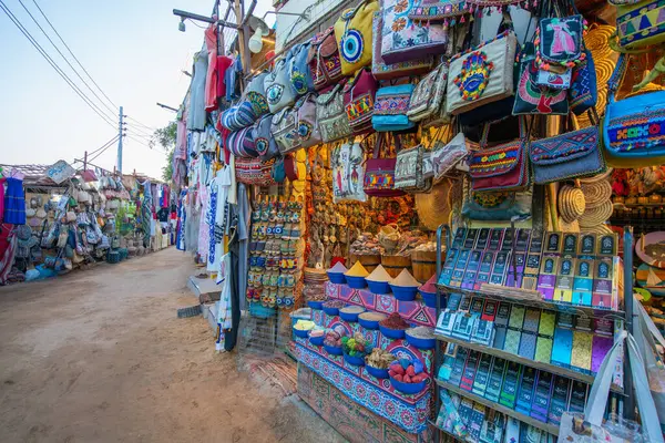 Aswan Lisesi Barajı, Mısır - 15 Ocak 2025: renkli mallarla dolu canlı Nubian köy pazarı. Çantalar, baharatlar ve el sanatları gün batımında sergilenecek.