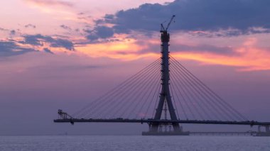 Güneş batarken Tayvan 'da dramatik gün batımı gökyüzü ile asma köprüsü inşa ediliyor..