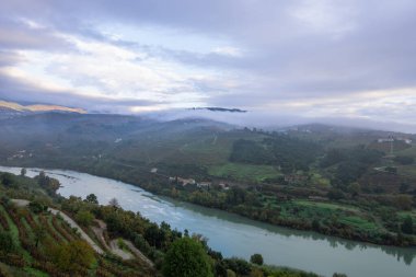 Portekiz 'in Lamego kentindeki bir otelin terasından Douro Nehri' nin saran büyüleyici manzarası dramatik bulutlu gökyüzünün altında..