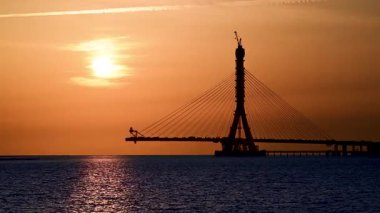 Tayvan 'da inşa halindeki Danshui Tamsui Köprüsü üzerinde pembe ve turuncu gökyüzü ile güzel bir gün batımı. 29 Nisan 2025 'te çekilmiş..