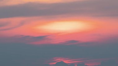 Batan güneş bulutların arasından Pinglin, New Taipei City, Tayvan 'a bakıyor, alacakaranlıkta yumuşak pembe ve turuncu renkler döküyor..