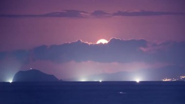 Dolunay, Tayvan 'ın New Taipei şehrindeki Shimen sahilinden yükselerek Xiao Jilong Yu' yu (Küçük Keelung Adası) ve geceleri meşgul balıkçı teknelerini aydınlatır..