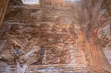 Aswan, Mısır - 16 Ocak 2025: Karmaşık duvar oymaları ve hiyeroglifler Ebu Simbel Tapınaklarından birinde belirgin bir şekilde sergilenmektedir. Detaylar antik Mısır sanatını ve mitolojisini yansıtıyor.