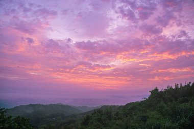 Shulin İlçesi New Taipei Şehri Tayvan 'ın verimli dağları üzerinde parlak renkleri ile soluk bir şehir manzarası ile gökyüzünü boyar..