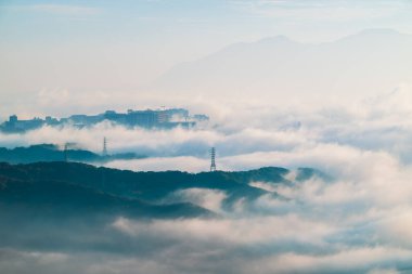 Shilin New Taipei Tayvan 'daki sisli dağların sabah manzarası soluk bir Taipei şehri silueti ve yumuşak bir gökyüzünün altındaki uzak tepeler.