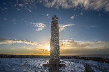 Lizbon, Portekiz - 15 Kasım 2024: Atlantik 'e tepeden bakan, ahşap çitli ve engin okyanus manzaralı manzaralı bir deniz feneri. Marks Cabo da Roca, Avrupa 'nın en batı noktası.