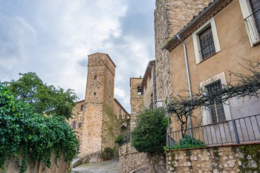 Trujillo İspanya 'nın tarihi kasabasındaki tarihi taş bina ve kulelerin dar sokak manzarası bulutlu bir gökyüzünün altında.