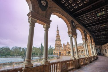 İspanya 'daki Sevilla Plaza de Espana, süslü bir atari salonu ve renkli fayanslarla yağmurlu bir alacakaranlık yakalar ve karamsar bir bahar akşamı atmosferi yaratır..