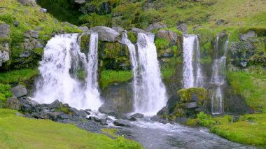 Güney Kıyısı ve Reykjanes, İzlanda - 11 Haziran 2025: Bereketli arazi ve açık gökyüzüyle çevrili Pencere Şelalesi yaz gezisi.