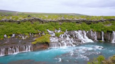 Hraunfossar Şelalesi 'nin, yaz boyunca Batı İzlanda' da turkuaz nehir sularıyla buluşan beyaz şelaleli görüntüleri. Gerçekten eşsiz bir doğa harikası..