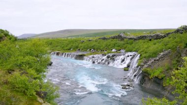 Yaz boyunca İzlanda 'daki çarpıcı Hraunfossar şelalelerini deneyin. Turkuaz buzul suları antik lav sahalarının üzerinde biricik bir doğal mucize yaratıyor..