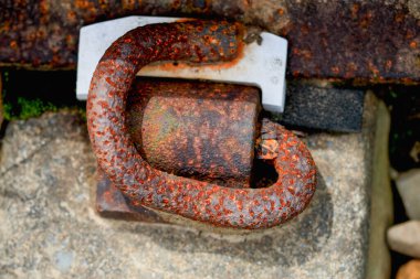 Pingxi, New Taipei City, Tayvan 'daki tren raylarının yakınında bulunan, taşa dayalı ve bulanık arkaplanlı ağır paslı bir demiryolu bağlantısı veya bağlama mekanizmasının detaylı bir yakın çekimi..