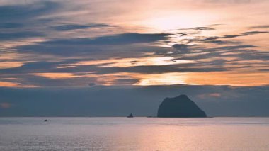 Waimushan, Keelung, Tayvan 'da büyülü bir yaz gündoğumuna tanıklık edin. Turuncu ve altın rengi gökyüzüne bakın, Keelung Adası 'nın manzarasıyla denizin üzerinde yansıyor..