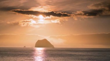 Güneş denizin üzerinde yükseliyor, Keelung Adası ve Tayvan 'ın Keelung kentindeki Waimushan kıyı şeridi yakınlarındaki Little Keelung Adası' na altın bir ışık tutuyor..